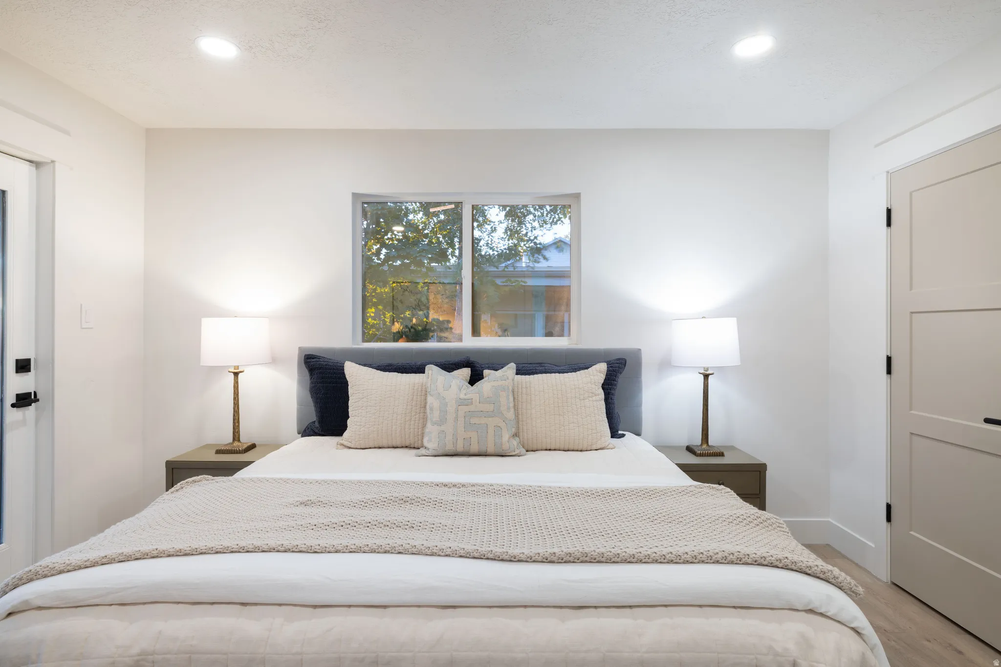 Bright room featuring recessed lighting, a window, and wood-finish flooring