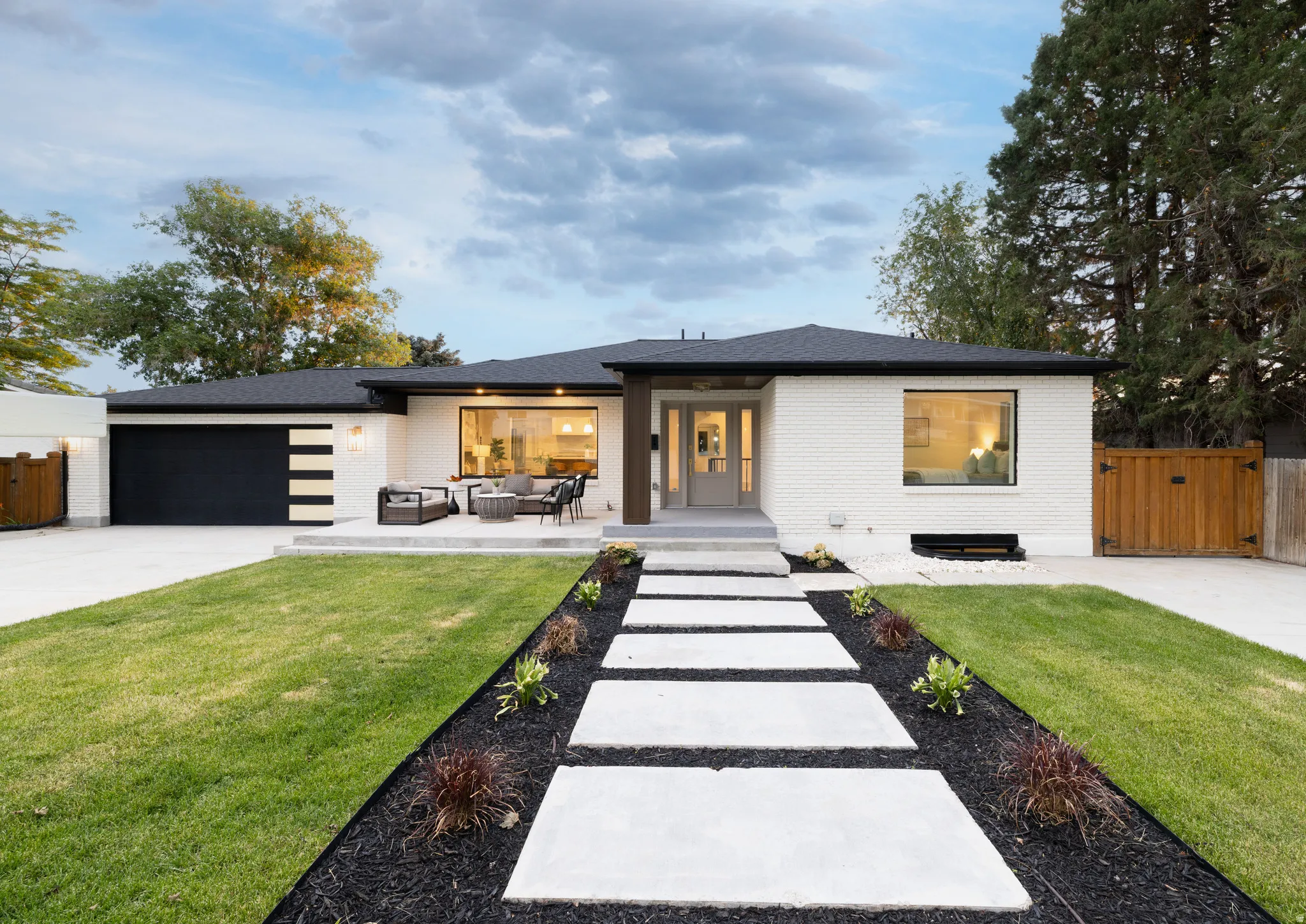 Contemporary single-story residence featuring a white brick exterior and a dark roof