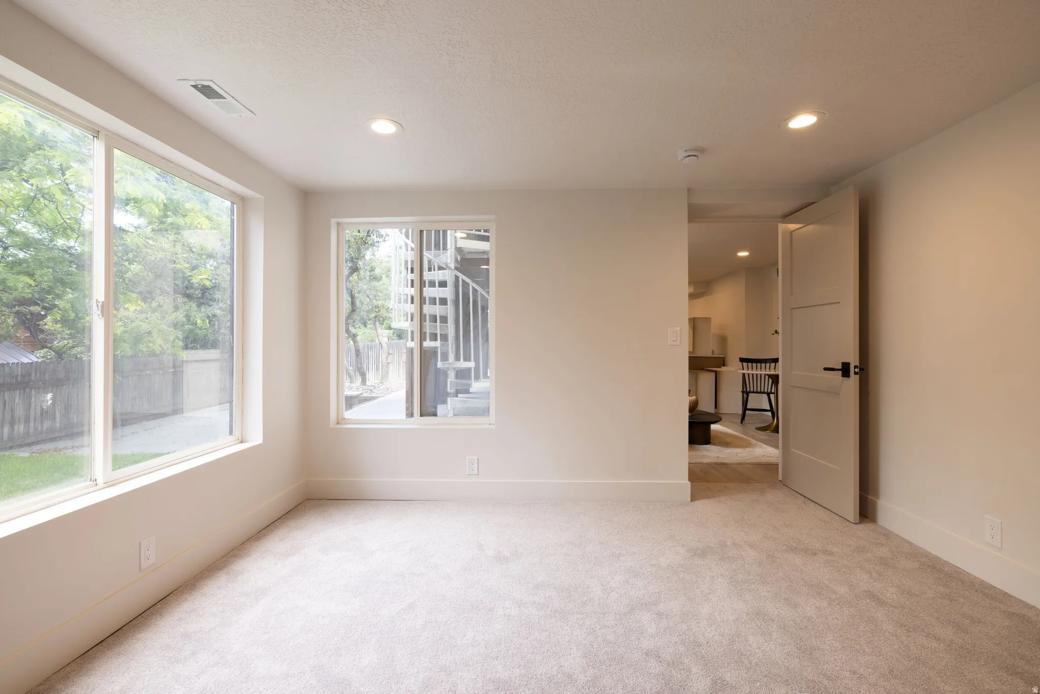 Carpeted room with recessed lighting and multiple windows