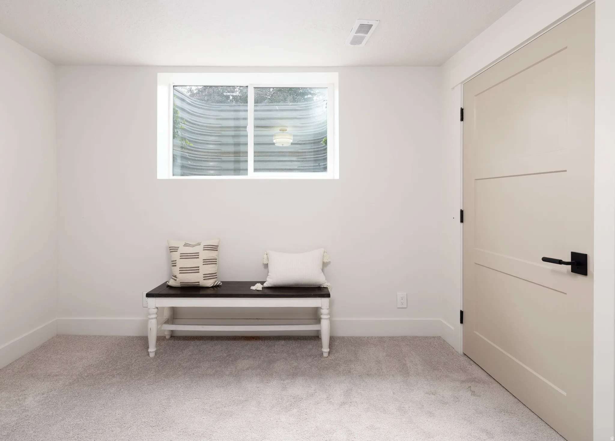 Neutral-toned interior with light gray carpet flooring and white walls