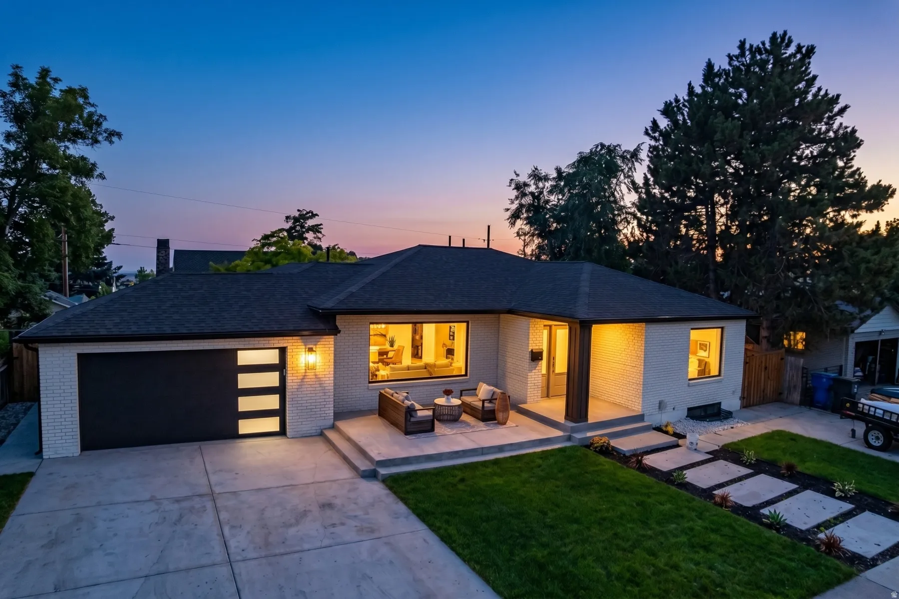 White brick exterior featuring a dark asphalt shingle roof