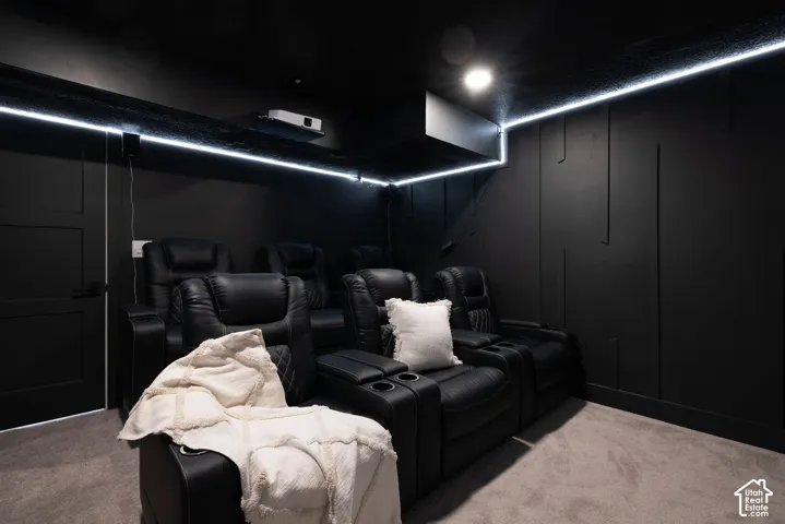 Dedicated media room featuring perimeter LED strip lighting, recessed ceiling lighting, and dark wall paneling