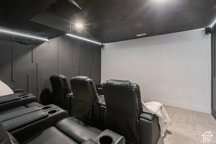 Custom wall paneling, recessed ceiling lights, integrated ceiling speaker, and wall-mounted projector