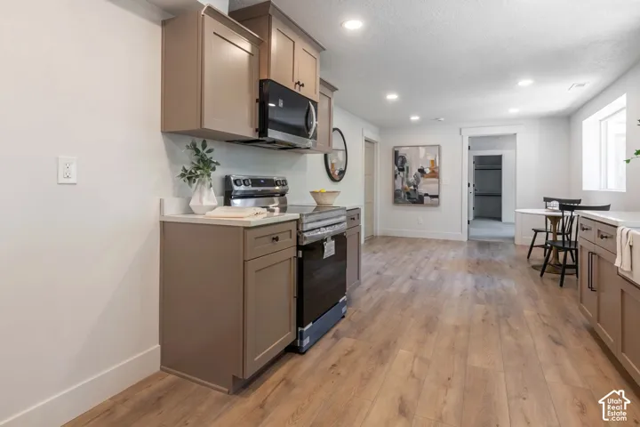 Kitchenette with wood-finish flooring, recessed lighting, shaker-style cabinetry, and built-in microwave