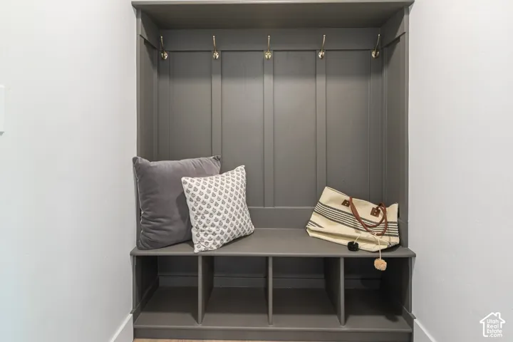 Built-in mudroom bench with paneled backing, integrated shelving, and brass-finish coat hooks
