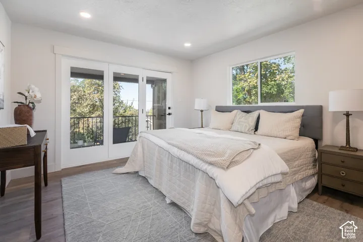Wood-finish flooring, recessed ceiling lighting, and a large window with white trim