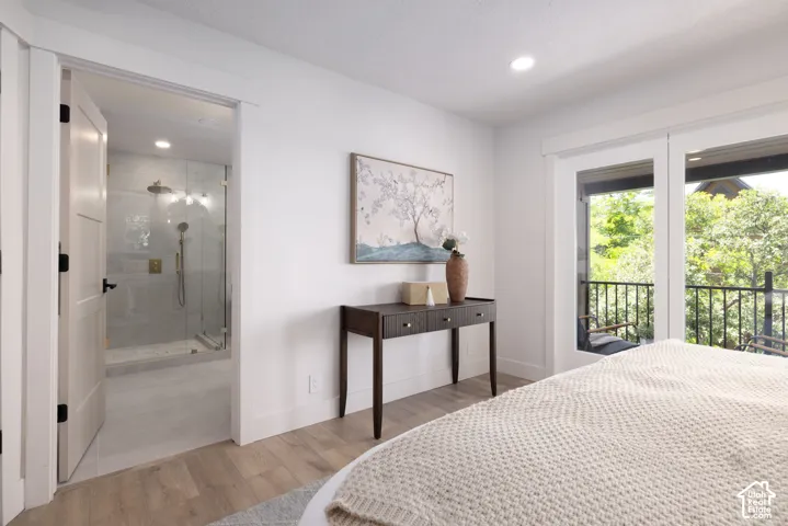 Spacious room featuring wood-finish flooring, recessed lighting, and a private balcony with black metal railings