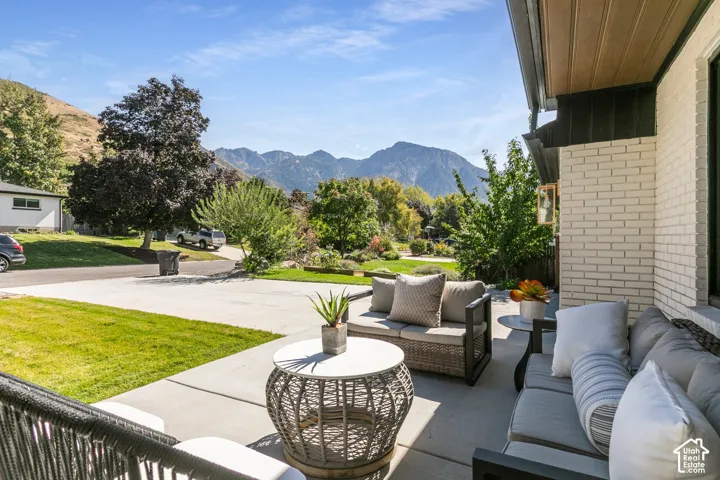 Paved patio with mountain backdrop, featuring a painted brick exterior and a soffit with wood-finish paneling