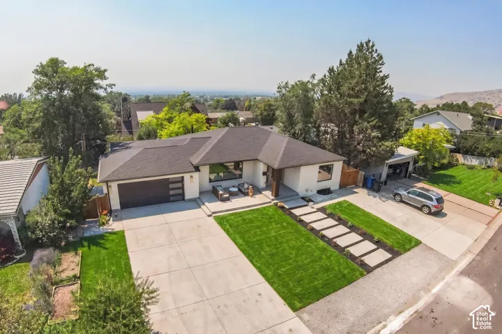 Contemporary single-story residence featuring a dark shingle roof and a two-car garage with a modern sectional door