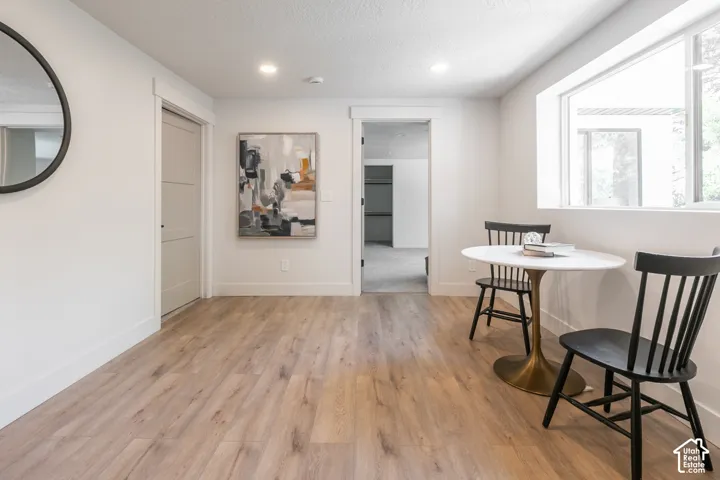 Recessed lighting, wood-finish flooring, and white trim
