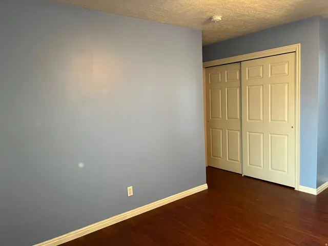 Hardwood-style flooring extends throughout the space, complemented by light blue walls and white baseboards