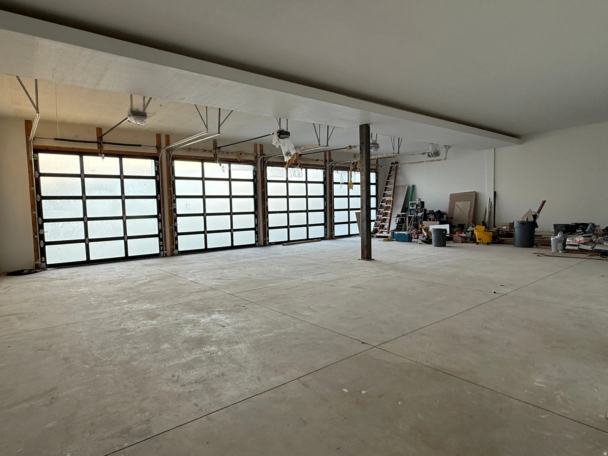 Concrete flooring with a white ceiling and exposed steel support beam