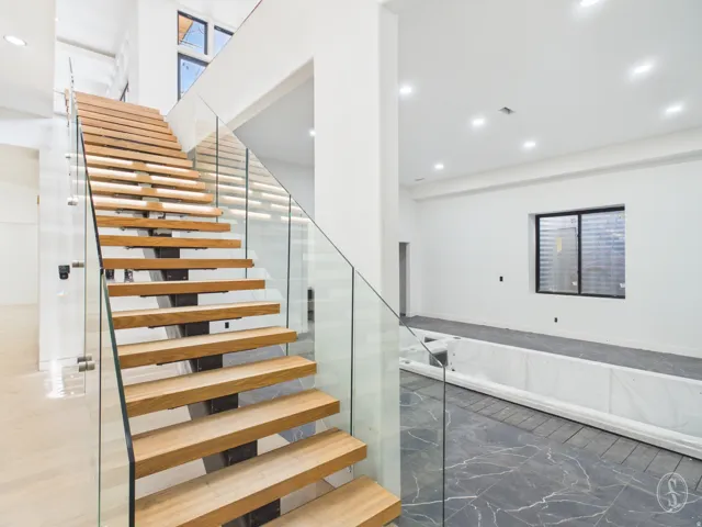 Floating wood-finish staircase with glass panel railing