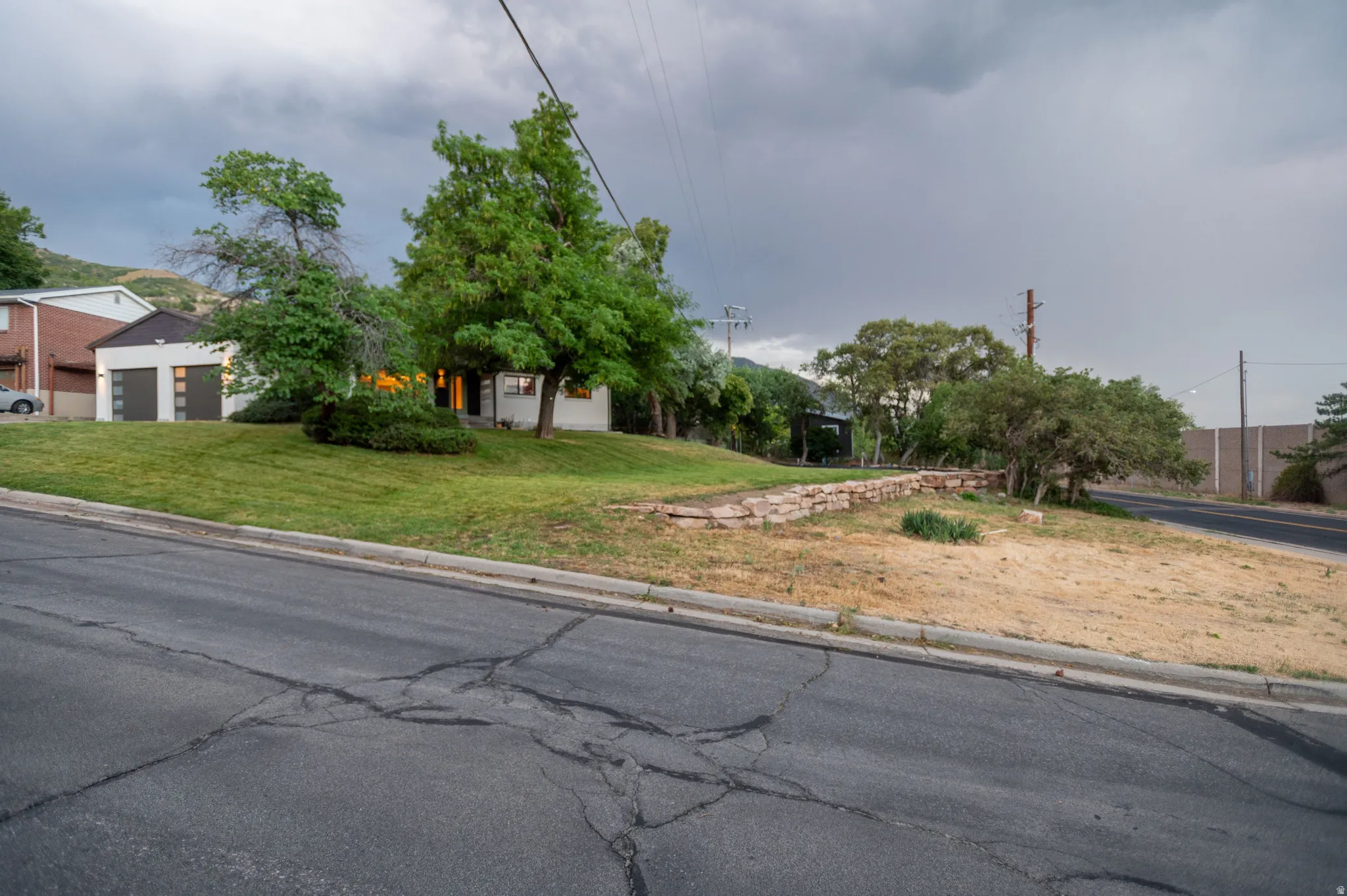 Property featuring a white-painted exterior, a modern garage with two doors, and a well-maintained grassy lawn