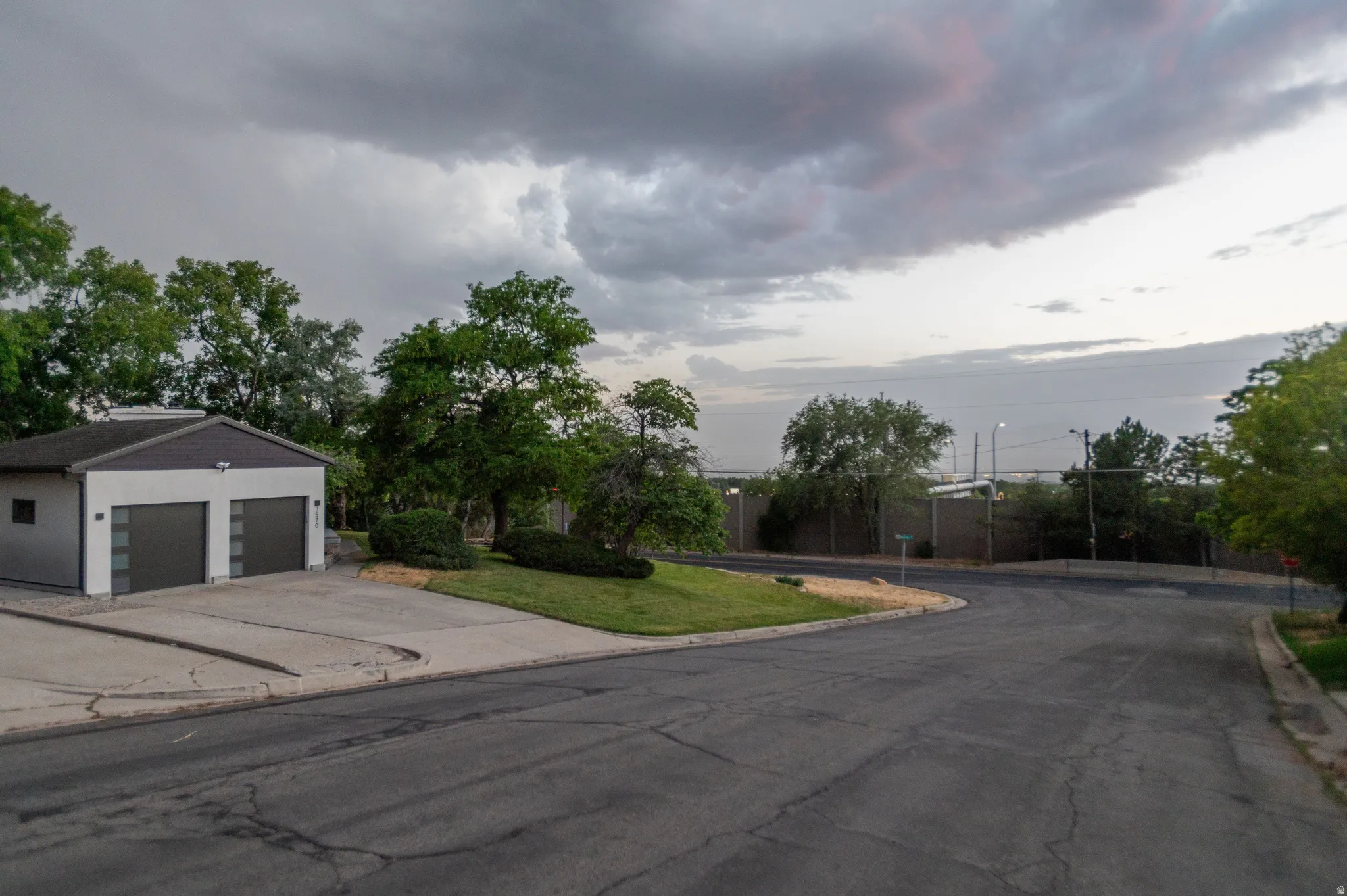 Contemporary detached garage with two garage doors featuring frosted glass panels and an exterior light fixture