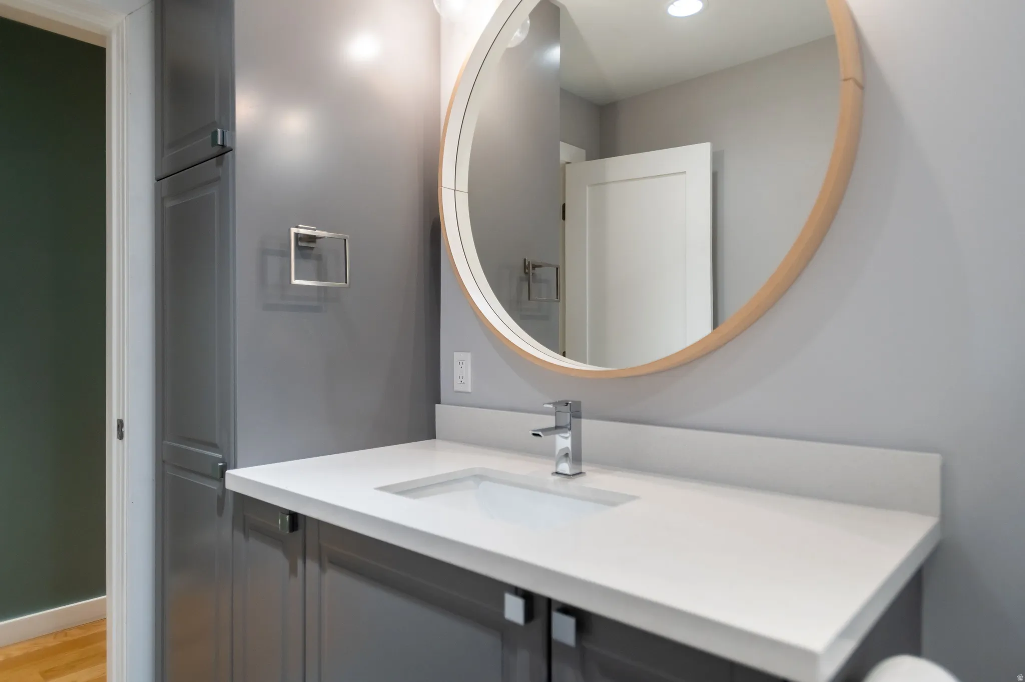 Bathroom vanity featuring a white rectangular undermount sink, a chrome single-handle faucet, and a white countertop