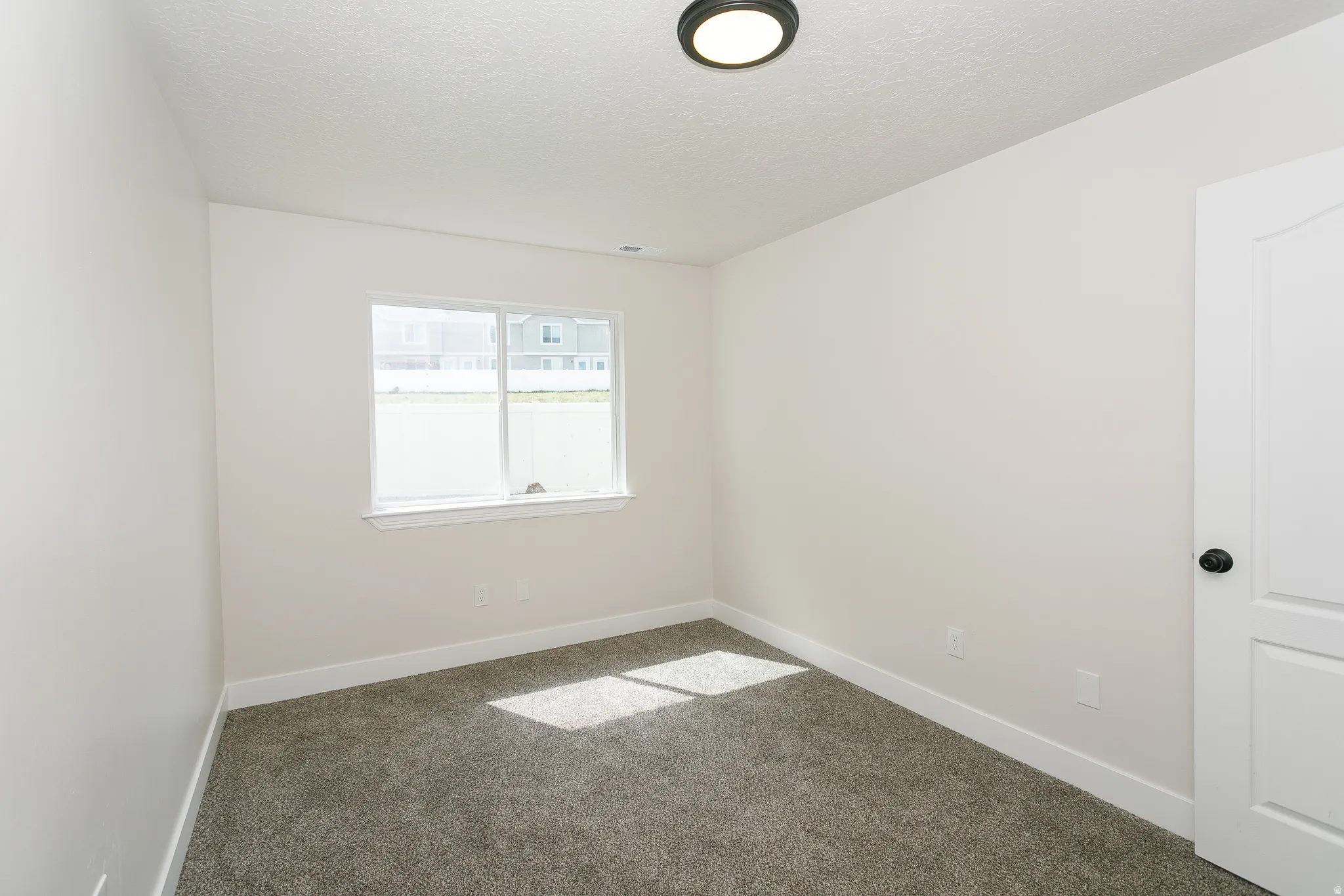 Room featuring neutral wall tones and plush gray carpet