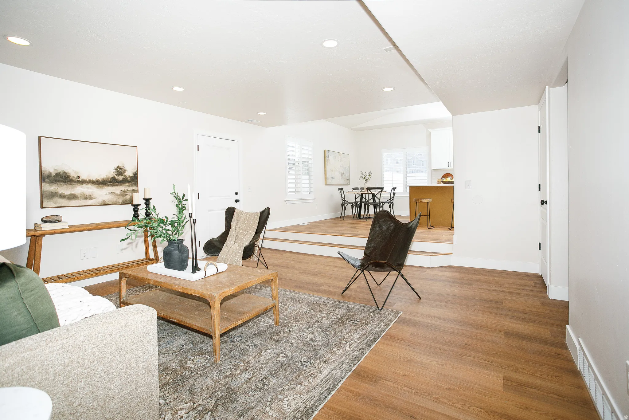 Bright living space featuring wood-finish flooring, recessed lighting, and white walls