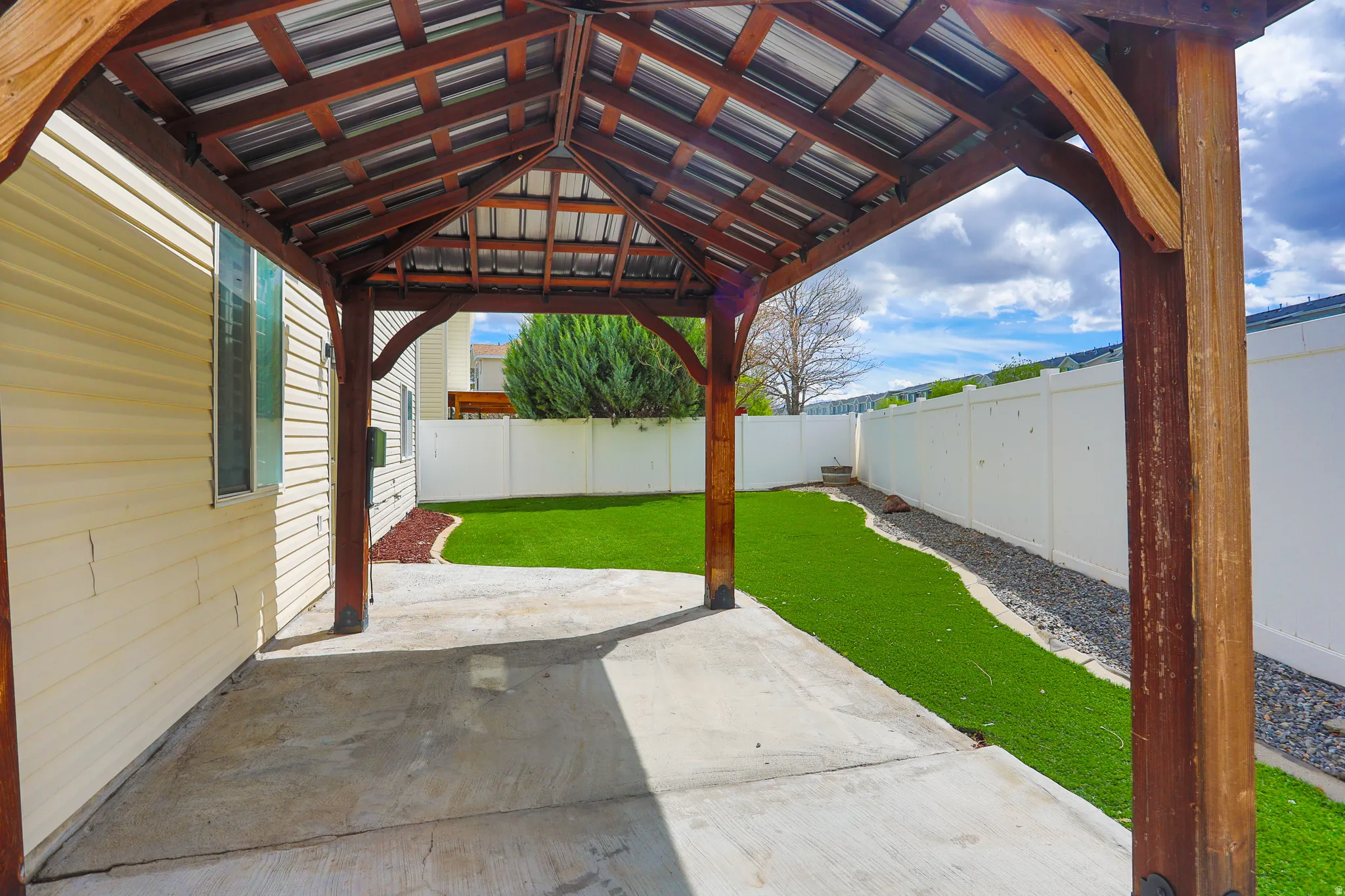 Covered patio area featuring a stained wood pergola with a metal roof