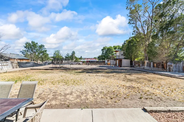 Expansive outdoor space featuring a concrete patio, gravel border, and a large yard area