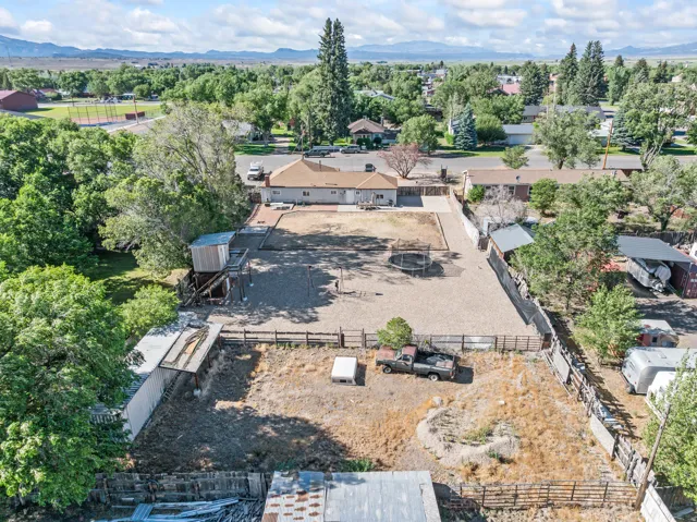 Single-story residence featuring an expansive rear yard, mature trees, and outbuildings