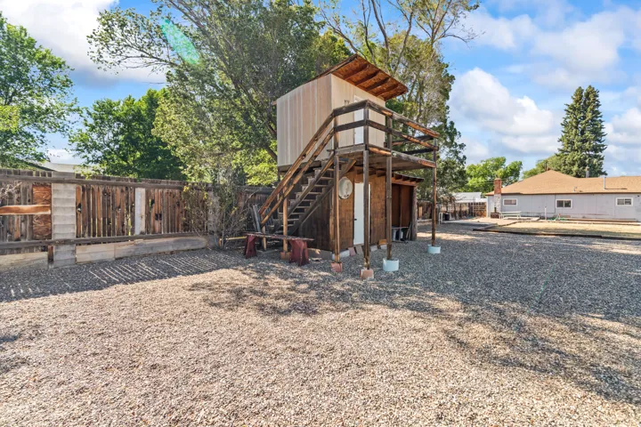 Elevated wooden structure featuring an open-air deck and covered ground-level space