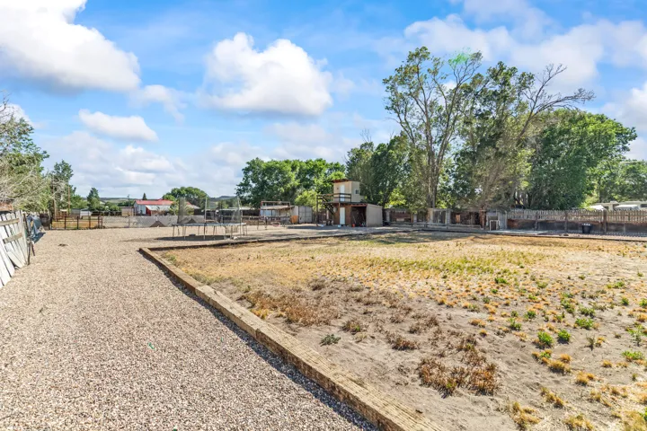 Expansive lot featuring a large gravel driveway, a substantial undeveloped land area, and mature perimeter trees