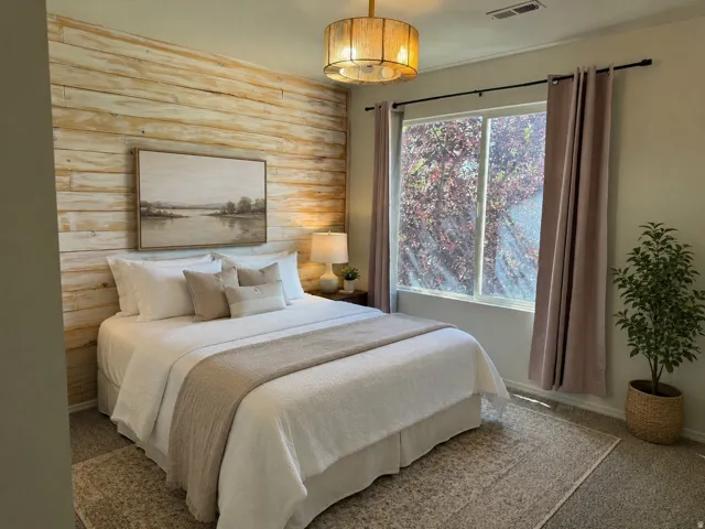 Bedroom featuring a textured wood-plank accent wall, overhead drum light fixture, and a large window
