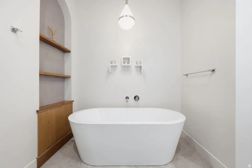 Freestanding soaking tub with wall-mounted fixtures