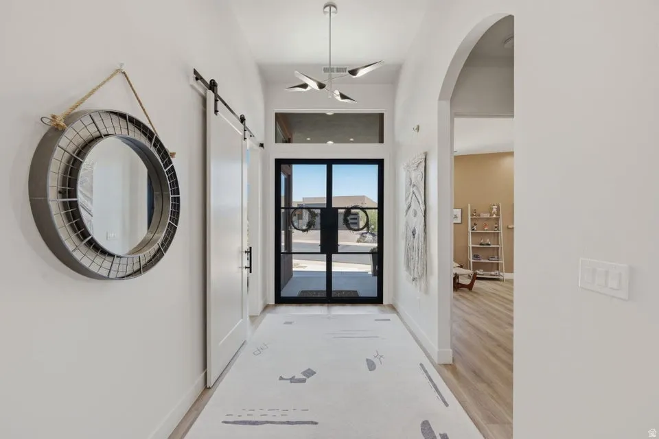 Entryway featuring a contemporary chandelier, transom window, and a black-framed glass front door