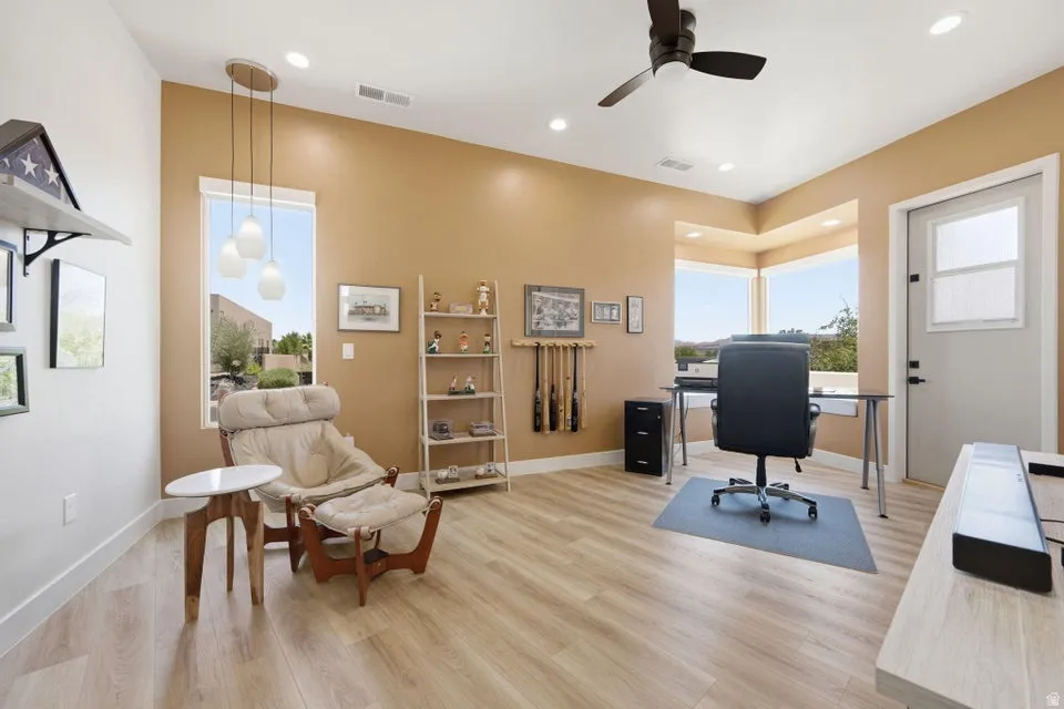 Spacious room featuring wood-finish flooring, recessed lighting, and a ceiling fan