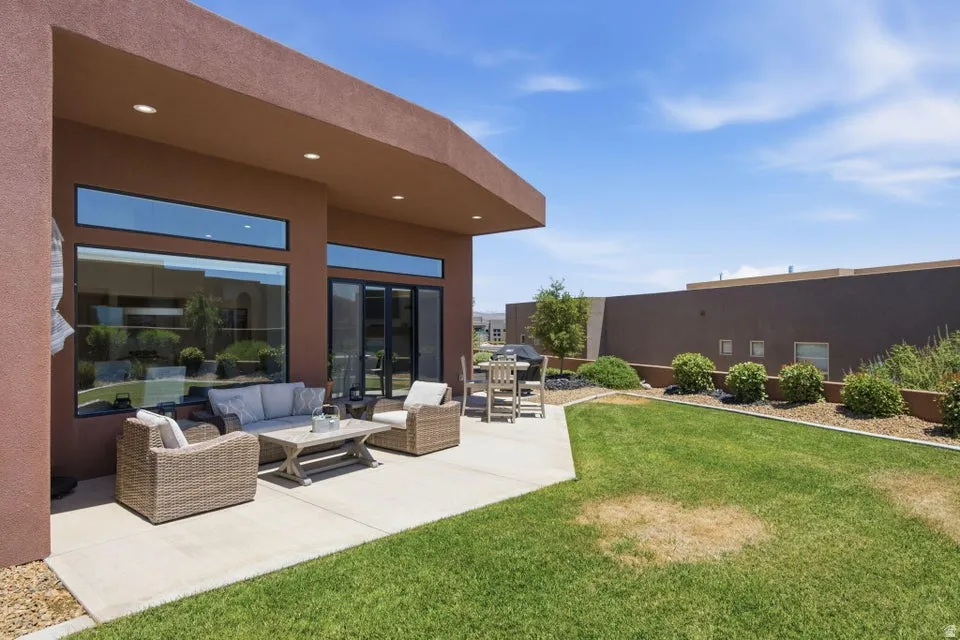 Expansive outdoor patio featuring a concrete surface, overhead lighting, and large windows