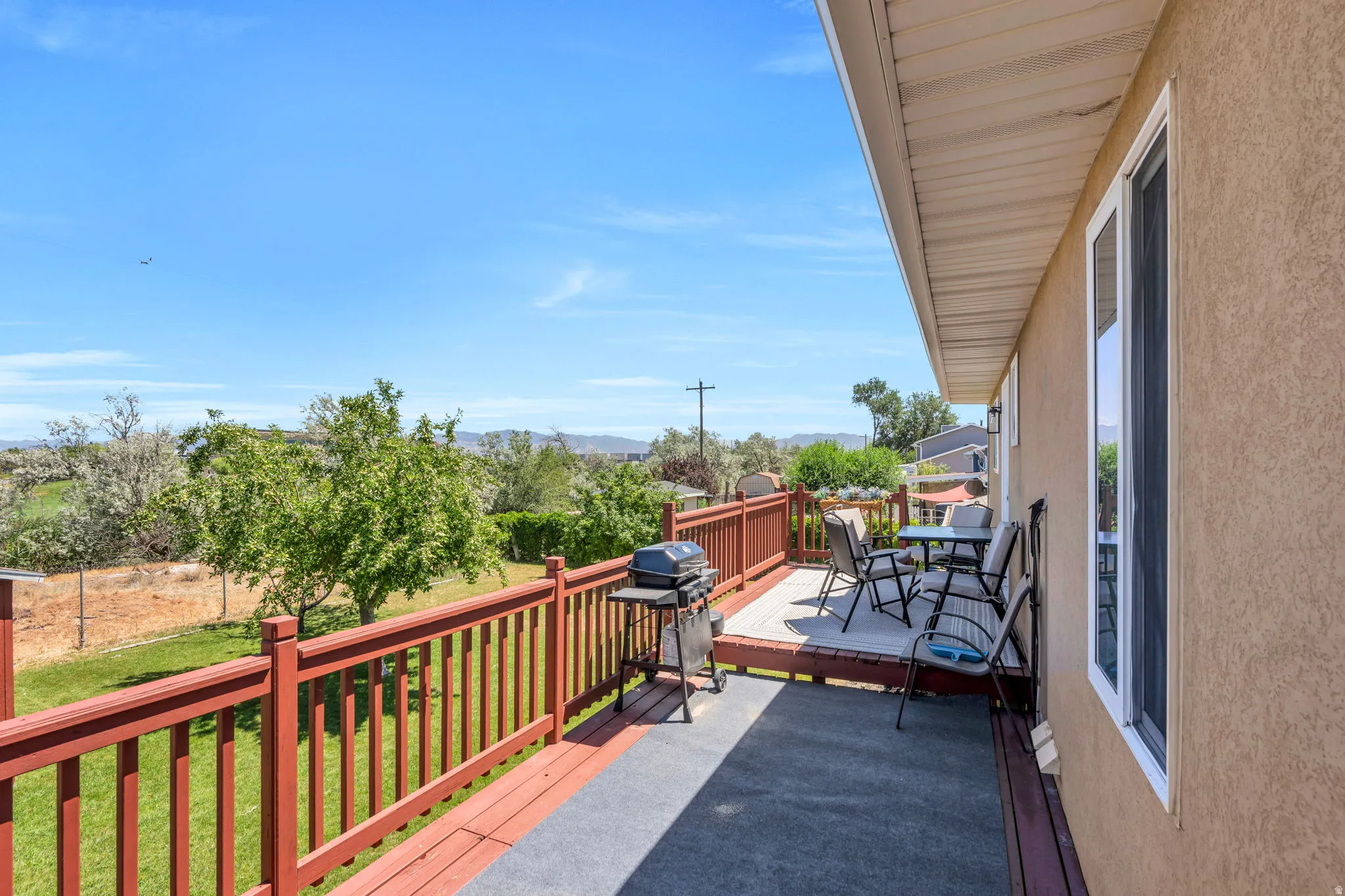 Upper-level deck featuring red-stained railings and a neutral floor covering