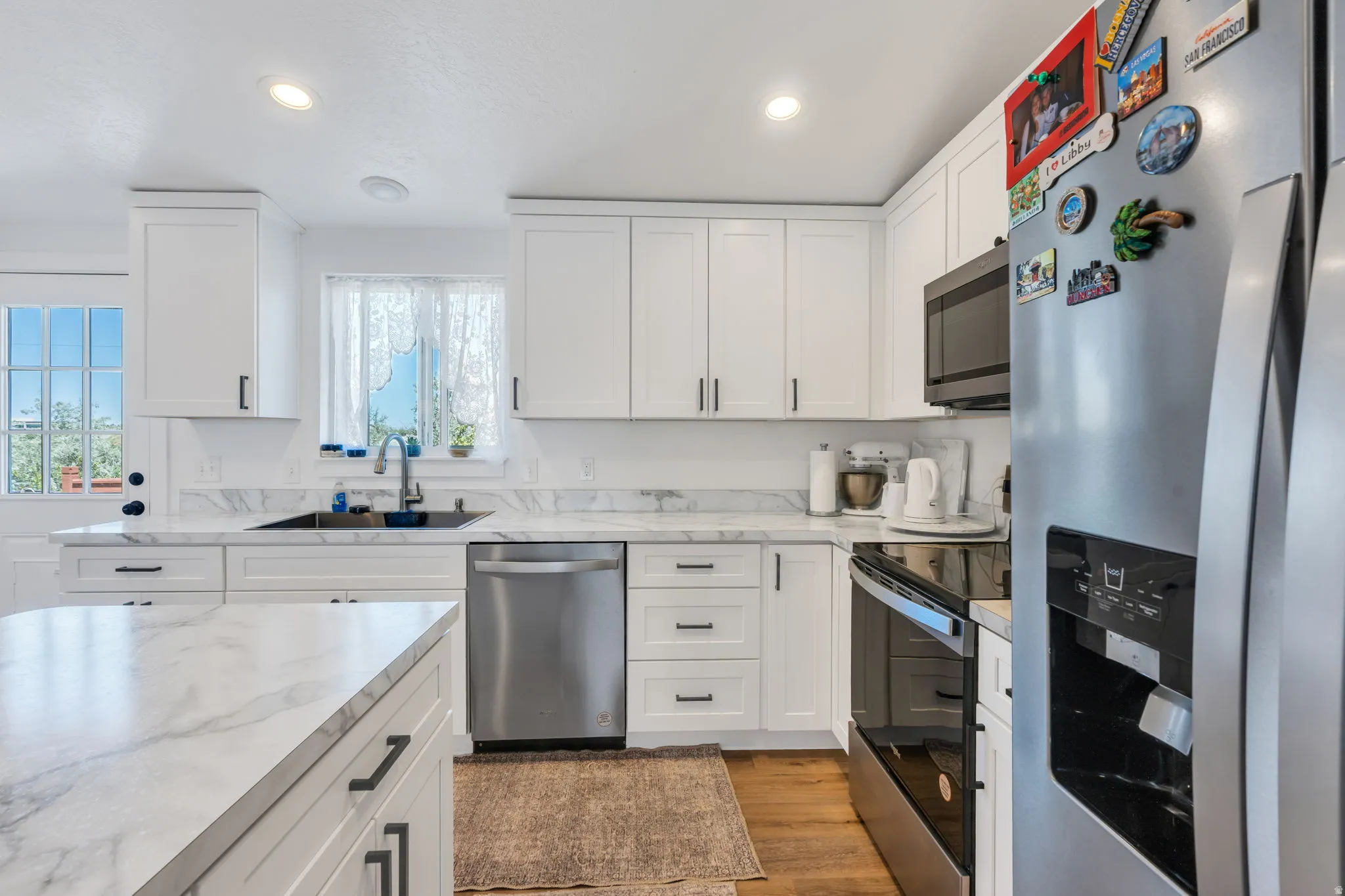 Contemporary kitchen featuring white cabinetry and light-toned countertops