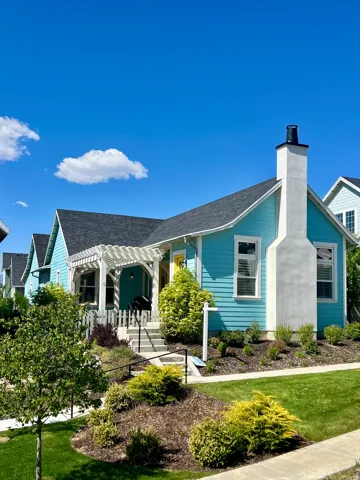 Turquoise siding with white trim and a prominent white chimney