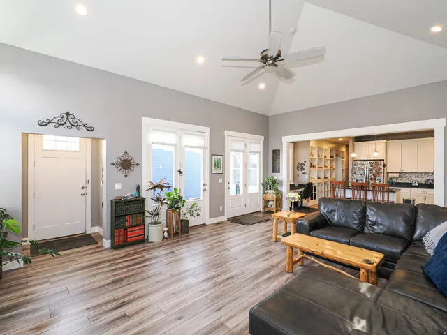 Vaulted ceiling with recessed lighting and ceiling fan, wood-finish flooring, and white trim throughout