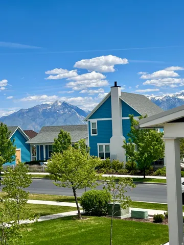 Modern residential architecture featuring a vibrant teal facade, white trim, and a prominent chimney