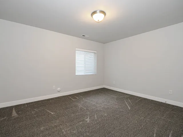 Neutral-toned walls complement the gray carpeting