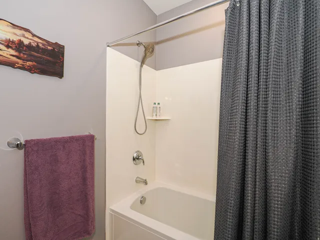 Tub/shower combination with a built-in shelf and polished chrome fixtures