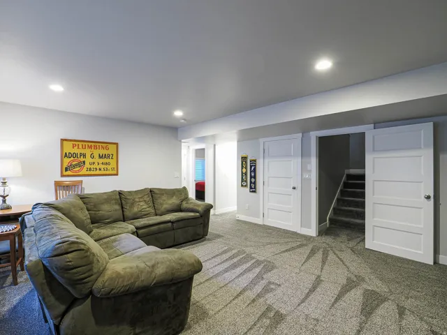 Recessed lighting, light gray walls, white trim, paneled interior doors, and textured carpeting