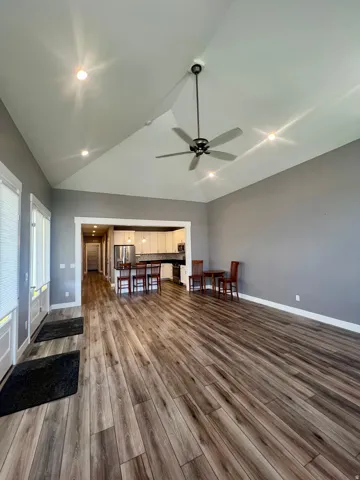 Vaulted ceilings with recessed lighting, wood-finish flooring, and a ceiling fan