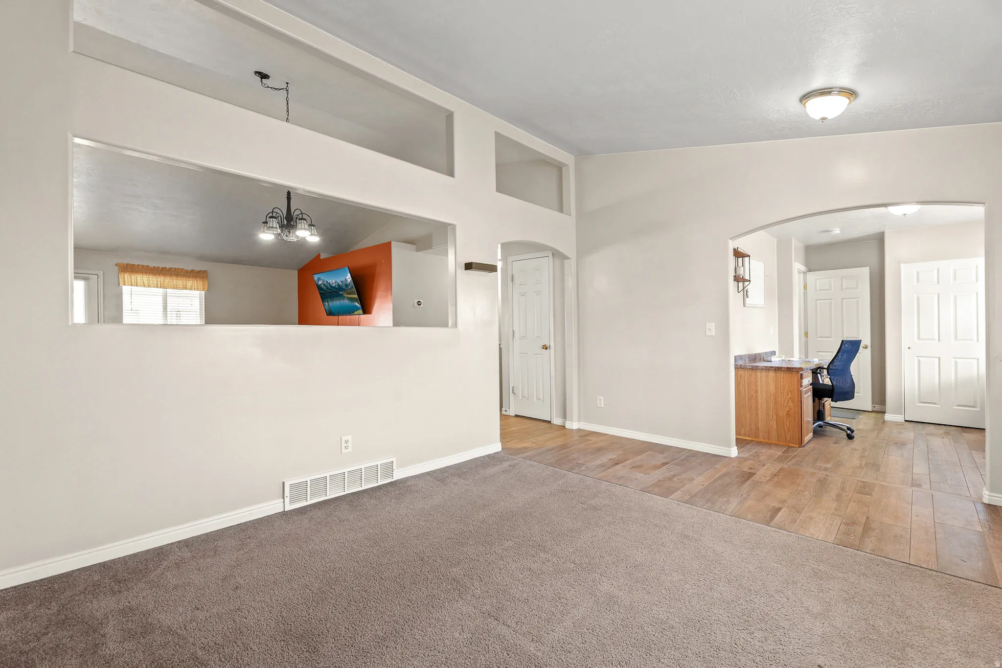 Upon entry, you're welcomed by a spacious living room on the left and a dedicated home office on the right.