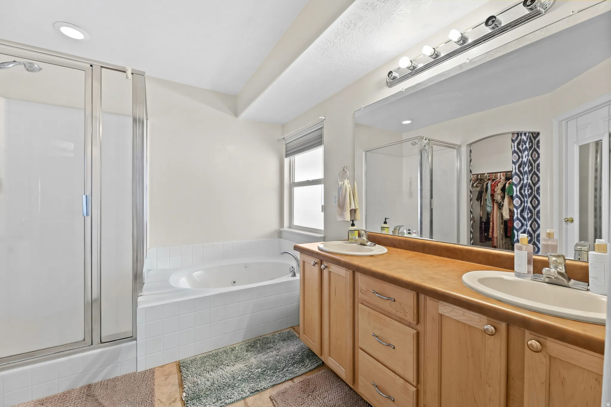 Enjoy a spa-like primary bathroom featuring his-and-her vanities, a separate walk-in shower, a jetted tub, and an oversized walk-in closet.