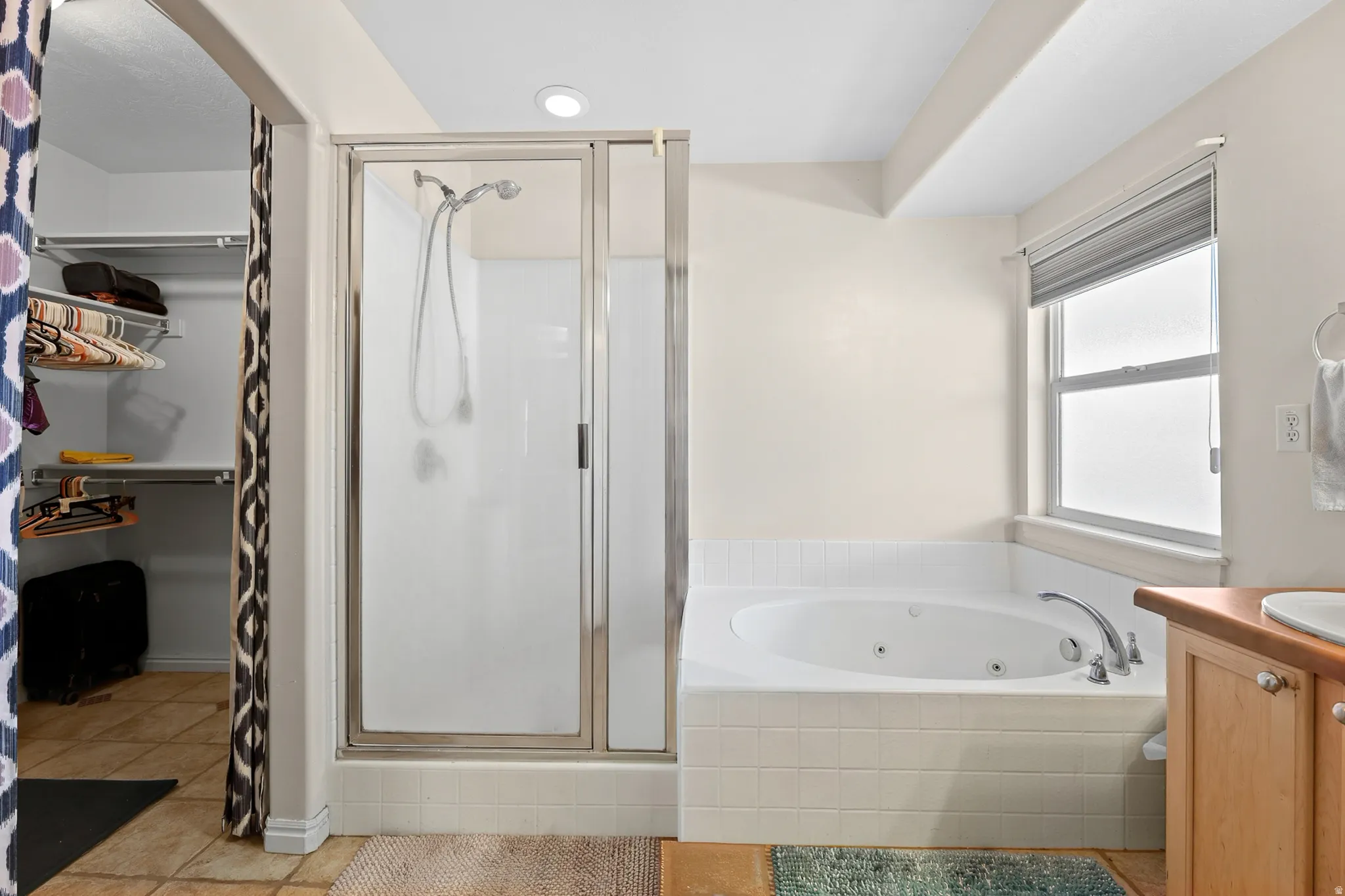 Enjoy a spa-like primary bathroom featuring his-and-her vanities, a separate walk-in shower, a jetted tub, and an oversized walk-in closet.