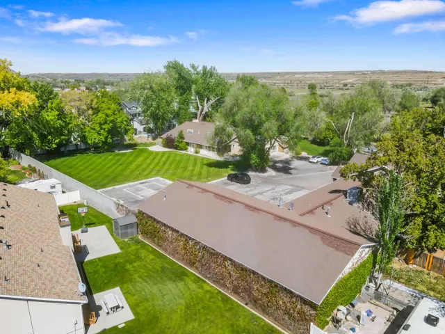 Expansive property featuring multiple structures, a large green lawn, and a paved parking area
