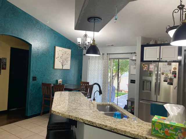 Kitchen featuring a granite-finish island with an undermount double sink and gooseneck faucet
