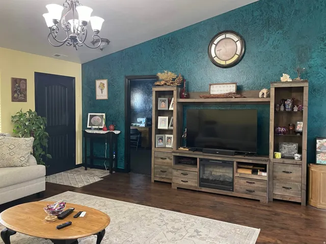 Living area feathttps://www.utahrealestate.com/lip.wizard/run/step/2/hbid/5469225#uring wood-finish flooring, a decorative chandelier, and a built-in media center with an electric fireplace