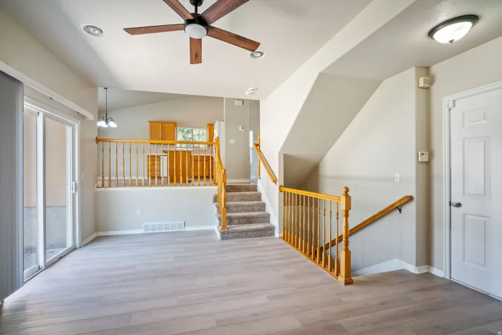 Spacious living area featuring wood-finish flooring, a ceiling fan, and recessed lighting