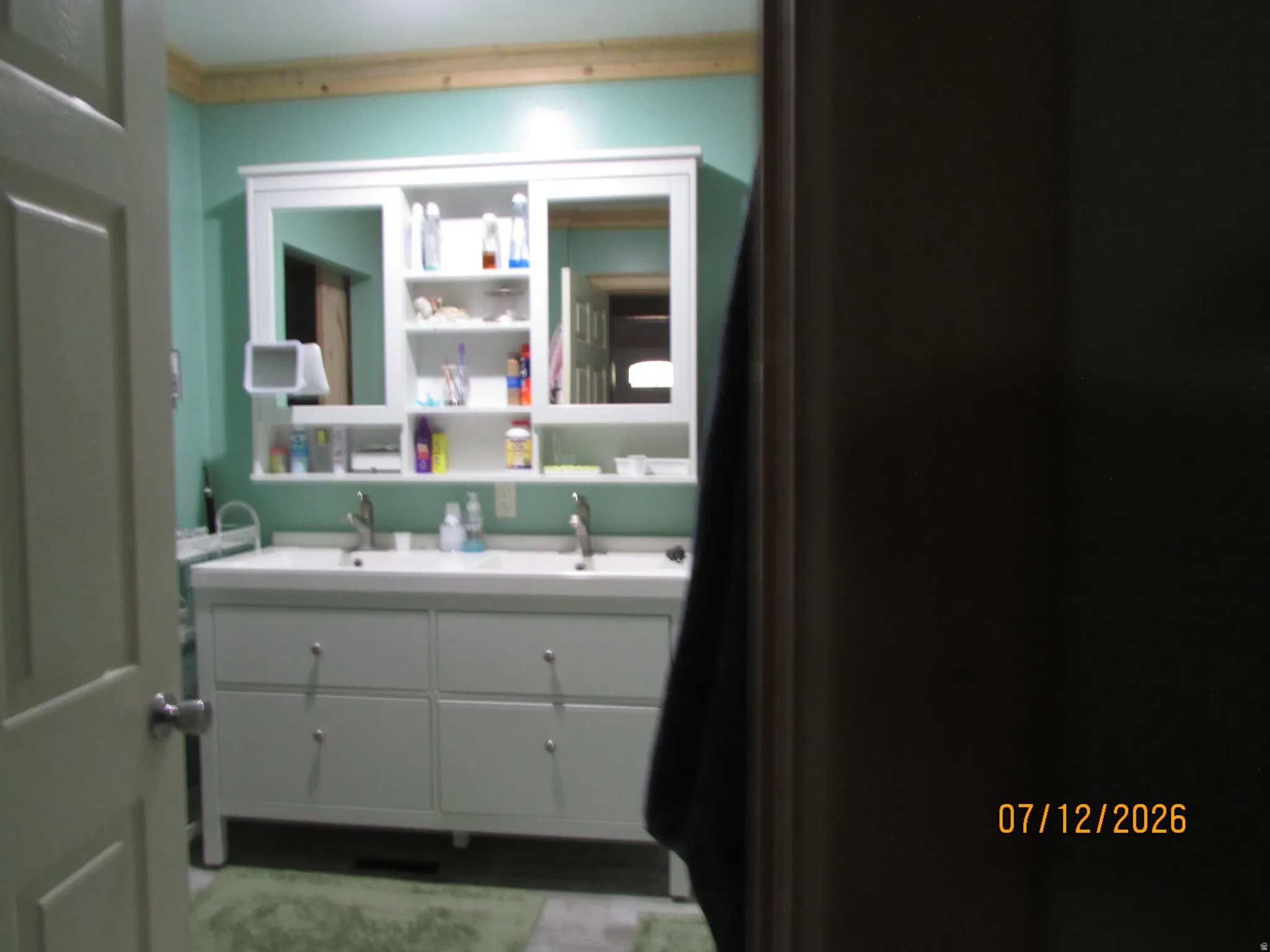 Dual vanity with integrated sinks, white cabinetry, and brushed nickel hardware