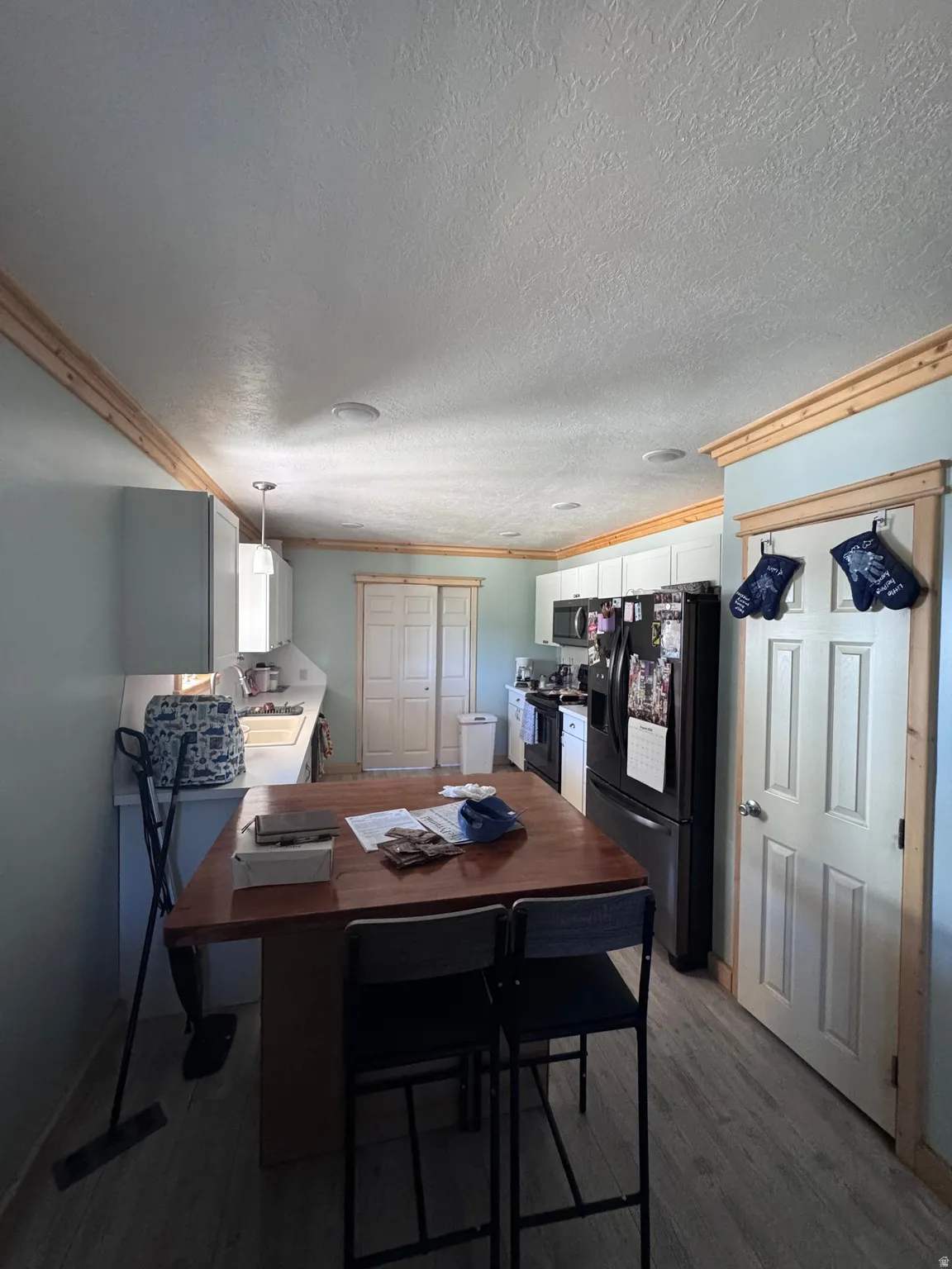 Functional home office featuring a wood-finish desk with integrated workspace, recessed ceiling lighting, white six-panel closet doors, and neutral wall finishes